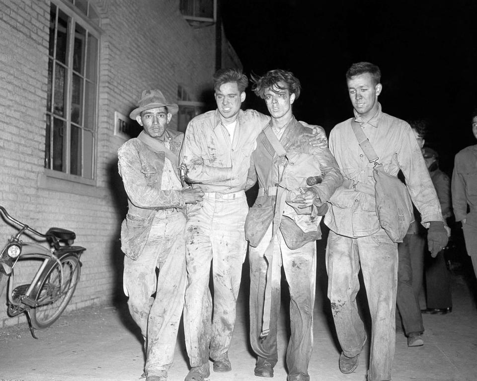 Four dazed and battered rescue workers limp back from the danger area along the waterfront at Texas City, Texas, April 17, 1947 shortly after a new series of blasts and fire swept the area.