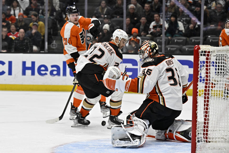 Anaheim Ducks goaltender John Gibson, right, blocks a shot by Philadelphia Flyers right wing Owen Tippett, left, with Ducks defenseman Kevin Shattenkirk, center, defending during the first period of an NHL hockey game in Anaheim, Calif., Monday, Jan. 2, 2023. (AP Photo/Alex Gallardo)