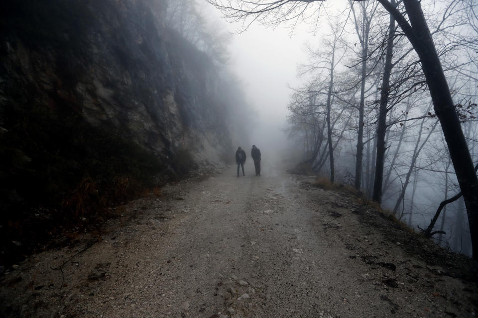 Migrants walk on a road on the Pljesevica Mountain in a attempt to illegally cross the border into Croatia, near Bihac, northwestern Bosnia, Thursday, Nov. 14, 2019. The European Union's top migration official is warning Bosnian authorities of a likely humanitarian crisis this winter due to appalling conditions in overcrowded migrant camps in the country. (AP Photo/Darko Vojinovic)