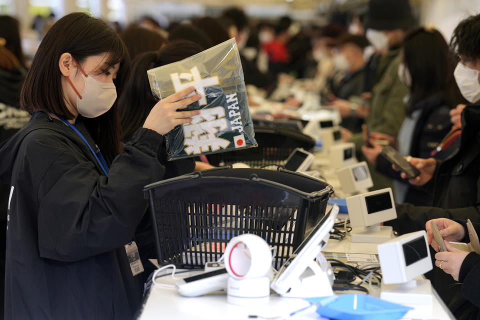 A fan of Japan's Shohei Ohtani buys a souvenir with his name on at a shop prior to the Pool B game between Japan and China at the World Baseball Classic (WBC) at the Tokyo Dome Thursday, March 9, 2023, in Tokyo. The letters read "Shohei." Japanese baseball player Shohei Ohtani is arguably the game's best player. But he's more than just a baseball player. He's an antidote for many in his native country. (AP Photo/Eugene Hoshiko)