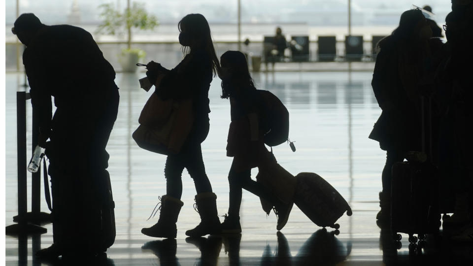 FILE - In this Wednesday, March 17, 2021, file photo, travelers walk through the Salt Lake City International Airport, in Salt Lake City. Vaccine passports being developed to verify COVID-19 immunization status and allow inoculated people to more freely travel, shop and dine have become the latest flash point in America’s perpetual political wars, with Republicans portraying them as a heavy-handed intrusion into personal freedom and private health choices. (AP Photo/Rick Bowmer, File)