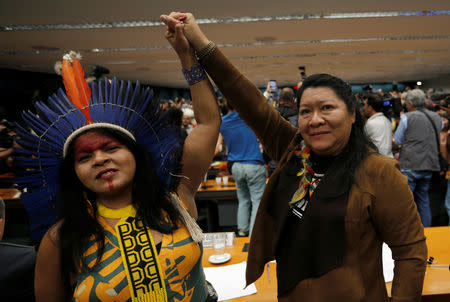 Congresswoman Joenia Wapichana and Indian Leader Sonia Guajajara raise their hands during a meeting with congressmen during the Terra Livre camp, or Free Land camp, at the National Congress in Brasilia, Brazil April 25, 2019. REUTERS/Adriano Machado