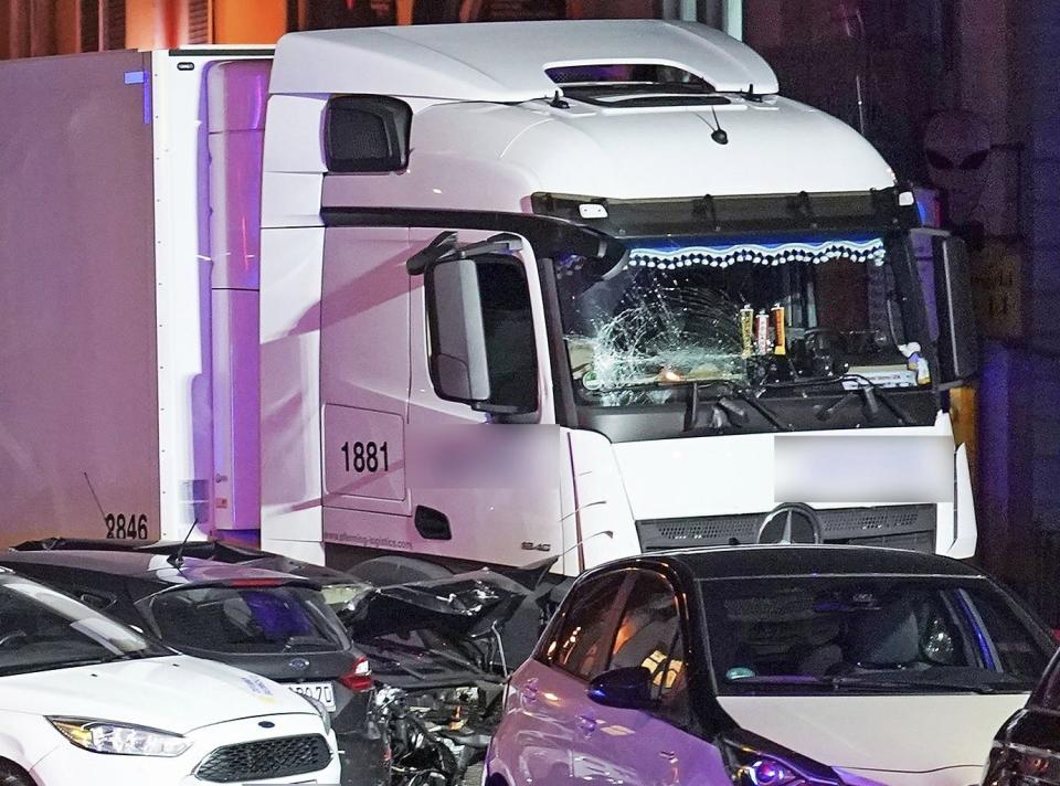 In this Monday, Oct. 7, 2019 photo s truck stands between damaged cars in Limburg, Germany. The truck drove into a line of eight cars in Limburg late Monday afternoon, pushing the vehicles into each other. Police said seven people were taken to hospitals and the driver also was slightly injured. He was detained. (Thorsten Wagner/dpa via AP)