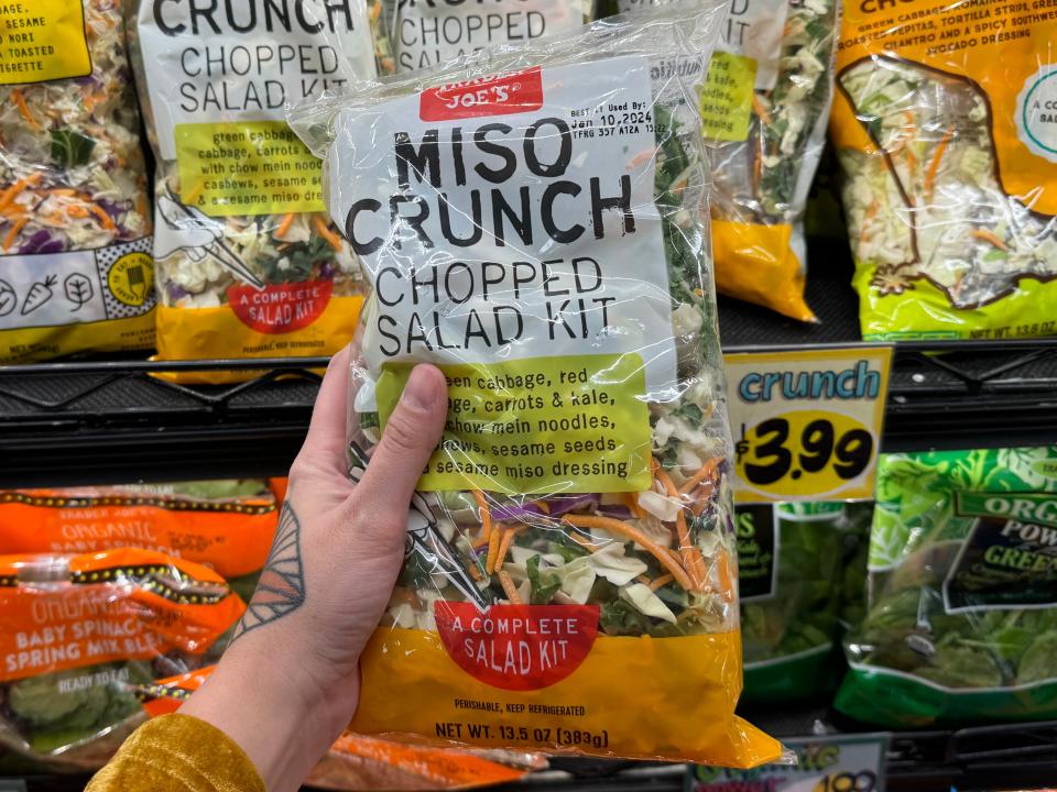 hand holding up a miso crunch chopped salad kit in trader joes