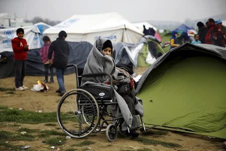 A temporarily stranded Syrian refugee is seen on a wheelchair on a field at a makeshift camp next to the Greek-Macedonian border, near the Greek village of Idomeni, February 24, 2016. REUTERS/Yannis Behrakis