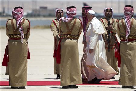 Pope Francis (3rd R) reviews the honour guard upon his arrival at Queen Alia International airport in Amman May 24, 2014. REUTERS/Andrew Medichini/Pool