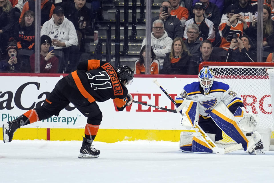 St. Louis Blues goaltender Jordan Binnington, right, deflects a shot by Philadelphia Flyers' Tyson Foerster, left, during a shootout in an NHL hockey game, Monday, March 4, 2024, in Philadelphia. (AP Photo/Matt Rourke)