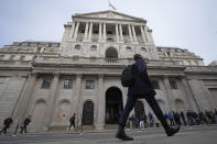 People walk past the Bank of England in London, Tuesday, Sept. 27, 2022. The British pound has stabilized in Asian trading after plunging to a record low, as the Bank of England and the British government try to soothe markets nervous about a volatile U.K. economy. The instability is having real-world impacts, with several British mortgage lenders withdrawing deals amid concern that interest rates may soon rise sharply. (AP Photo/Frank Augstein)