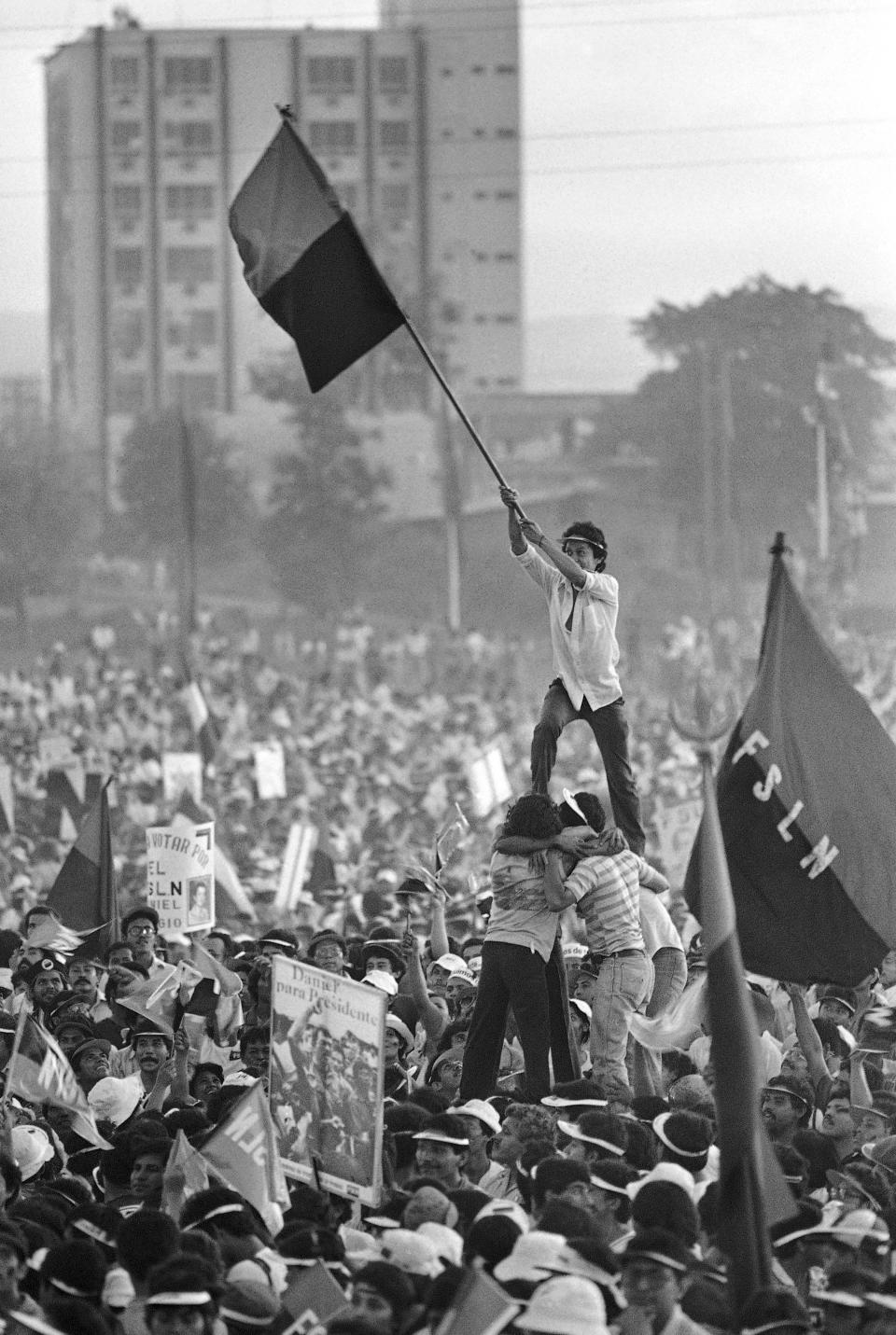 FILE - Sandinista youth form a human pyramid, waving their party colors in front of Commandante Daniel Ortega, Nov. 4, 1984, in downtown Managua, Nicaragua, during his last political rally of the presidential elections. Pat Hamilton, a combat veteran of the Vietnam War who covered the civil wars in Central America as a photojournalist for The Associated Press, and who later worked at Reuters covering the Gulf War in Iraq, died Sunday, Aug. 13, 2023, after a long struggle with cancer. He was 74. (AP Photo/Pat Hamilton, File)