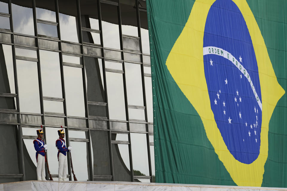 Soldiers stand guard next to a Brazilian flag on the ramp at the Planalto Palace in Brasilia, Brazil, Monday, Oct. 31, 2022, the morning after the re-election of former Brazilian President Luiz Inacio Lula da Silva. (AP Photo/Eraldo Peres)