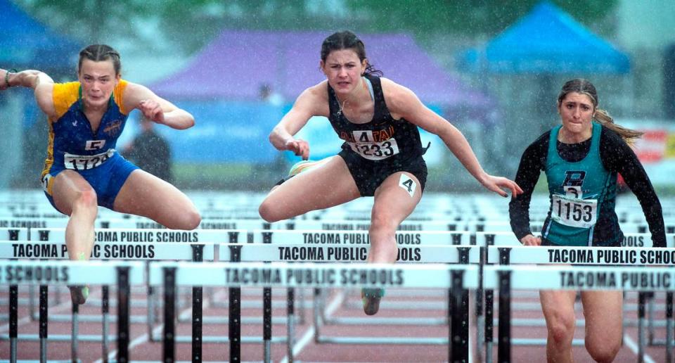 Capital junior Hana Moll (center) runs to a state championship in the 3A girls 100-meter hurdles during the second day of the WIAA State Track and Field Championships at Mount Tahoma High School in Tacoma, Washington on Friday, May 27, 2022.