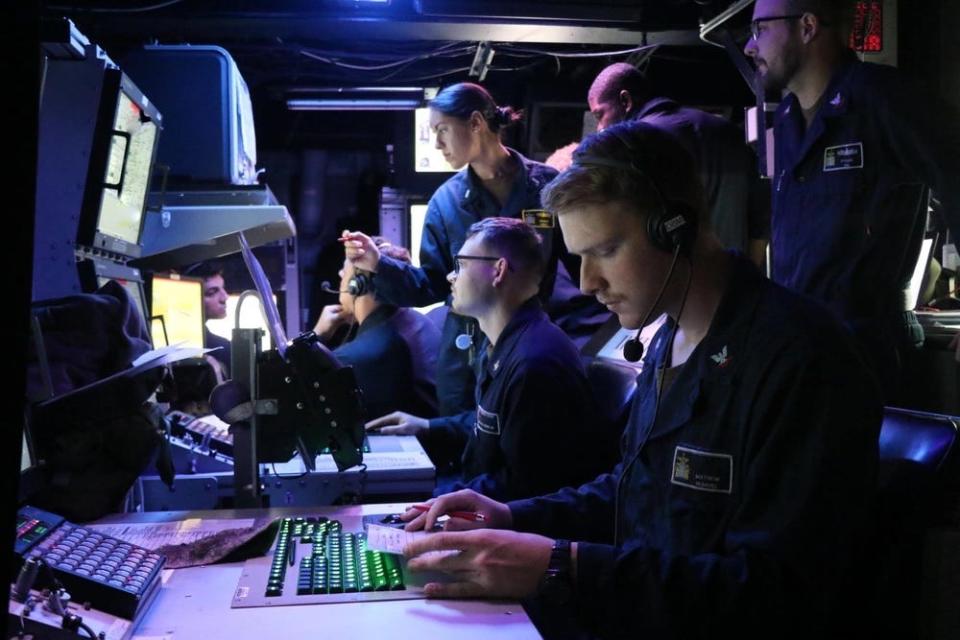 A photo of people in a command center.