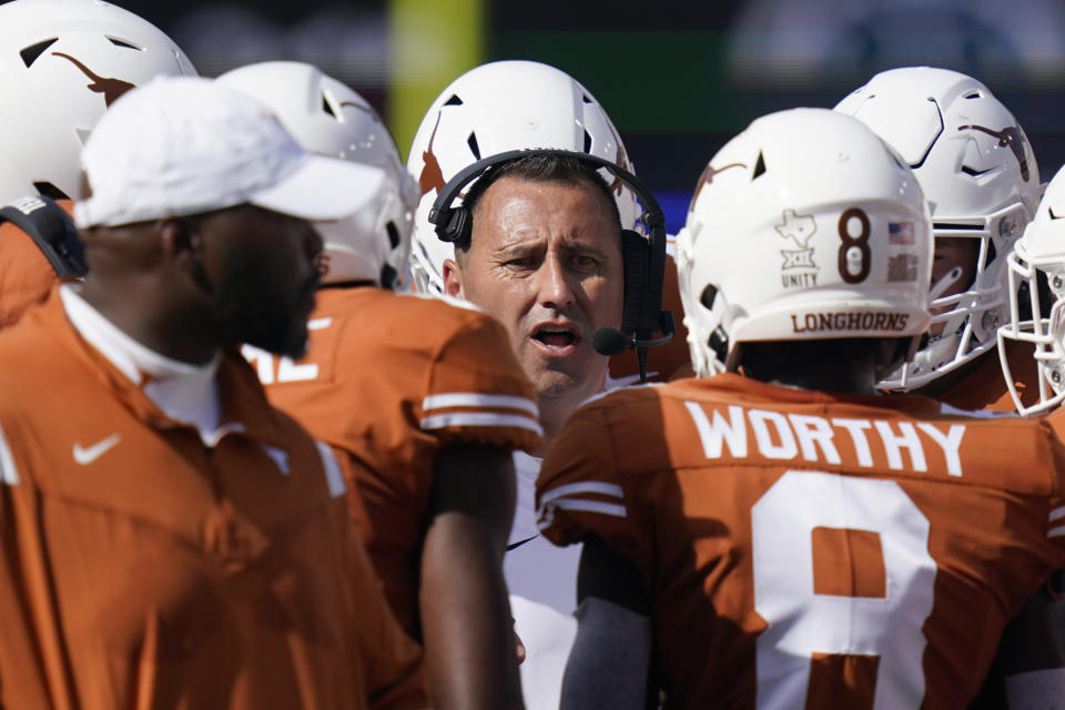 Texas coach Steve Sarkisian, center, talks with players during a timeout in the first half of an NCAA college football game against Louisiana-Lafayette, Saturday, Sept. 4, 2021, in Austin, Texas. (AP Photo/Eric Gay)
