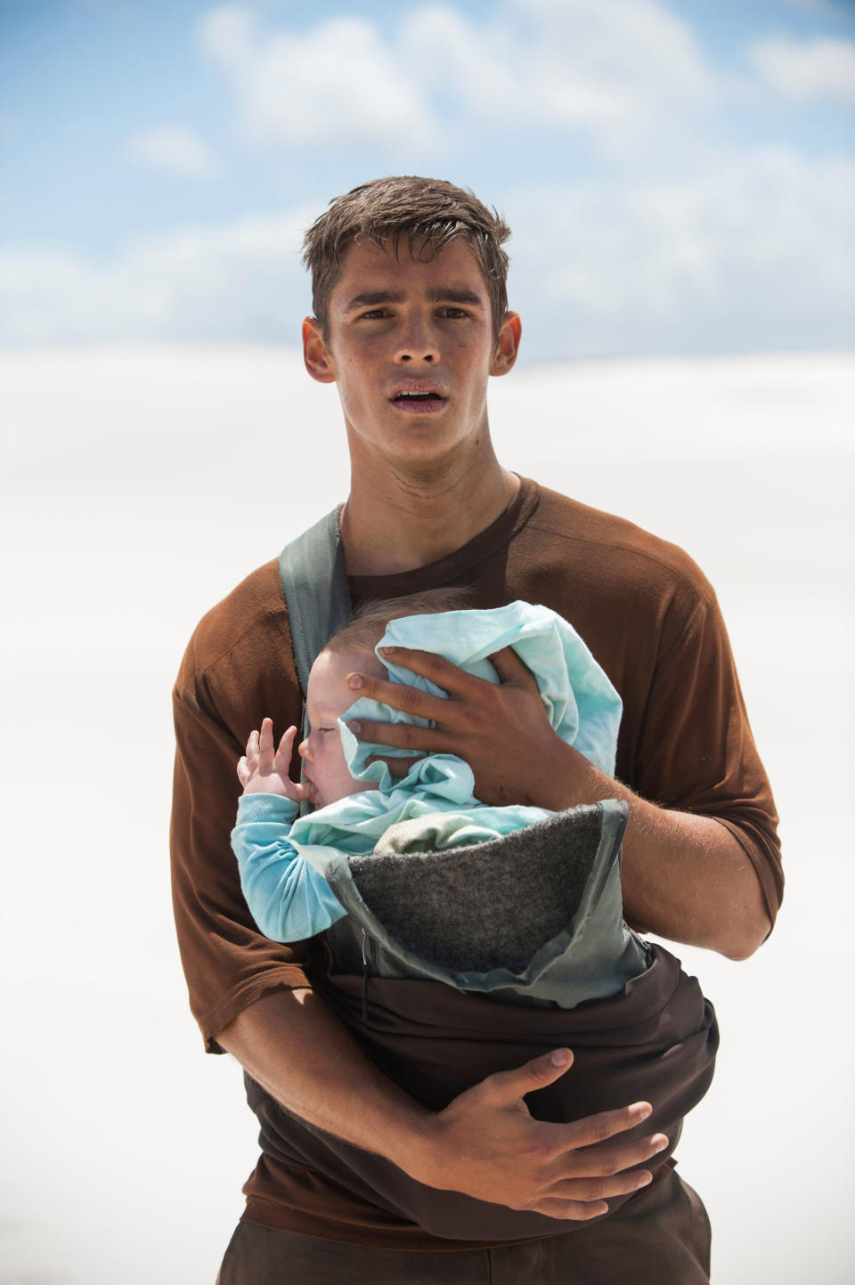 Brenton Thwaites as Jonas holding a baby