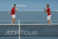 Novak Djokovic, left, and Viktor Troicki of Serbia react to a point against Pablo Carreno Busta and Feliciano Lopez of Spain come together during their ATP Cup tennis match in Sydney, Monday, Jan. 13, 2020. (AP Photo/Steve Christo)