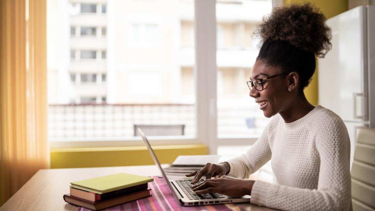 Afro Woman sitting at home and studying.