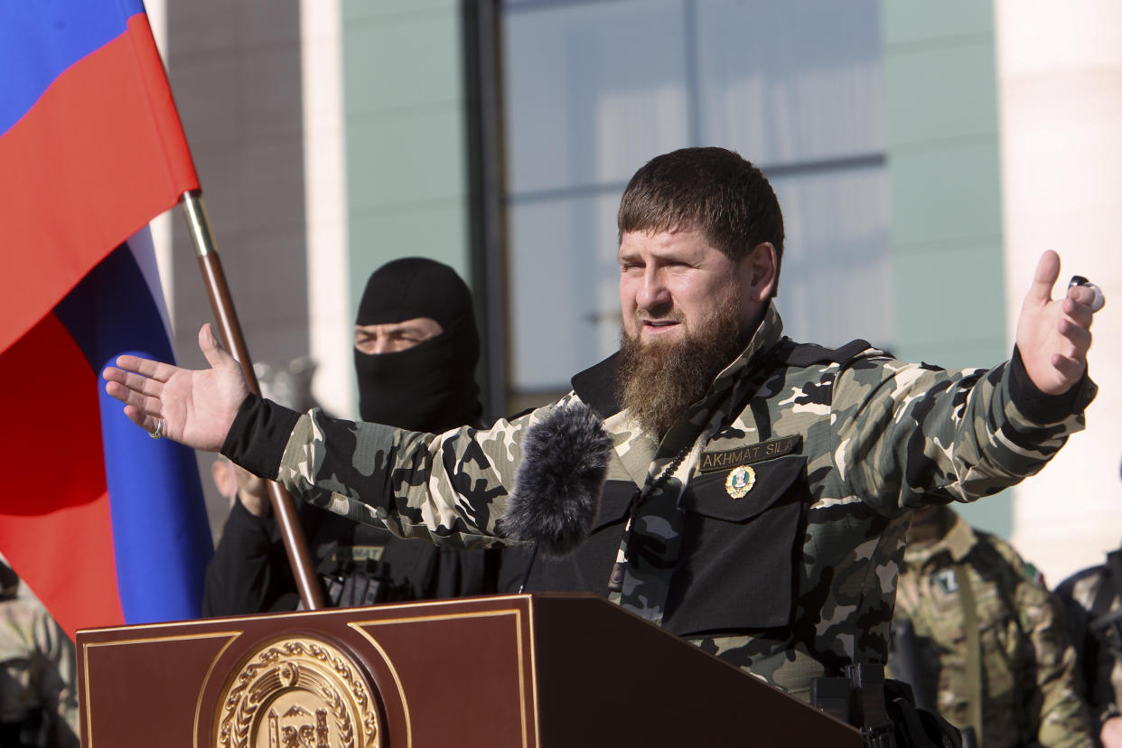 Ramzan Kadyrov, leader of the Russian province of Chechnya, extends his arms as he speaks at a lectern. 