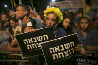 A woman holds signs during a protest against the violence towards the gay community in Tel Aviv August 1, 2015. The sign reads "hatred kills". REUTERS/Baz Ratner