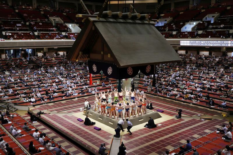 Spectators are seen as sumo wrestlers hold a ring-entering ceremony at the July Grand Sumo Tournament in Tokyo