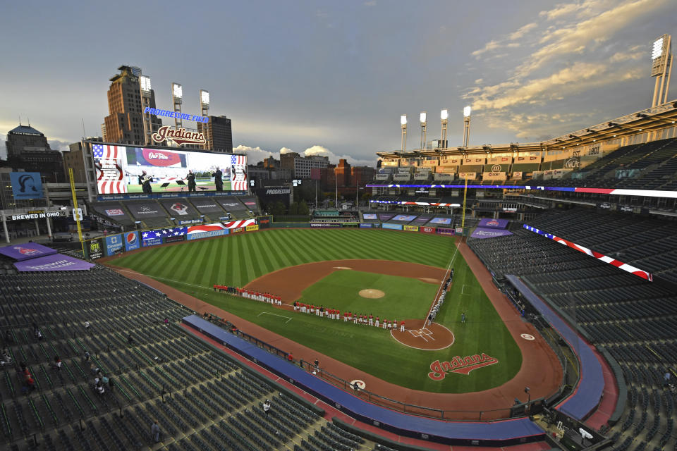 Players and coaches for the New York Yankees and Cleveland Indians stand for the national anthem before the start of Game 1 of an American League wild-card baseball series, Tuesday, Sept. 29, 2020, in Cleveland. (AP Photo/David Dermer)