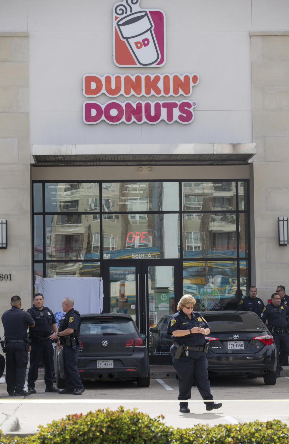 Houston Police officers investigate the scene of a fatal shooting at a Dunkin' Donuts on the 5800 block of Memorial Drive Friday, Feb. 15, 2019, in Houston. (Godofredo A. Vasquez/Houston Chronicle via AP)