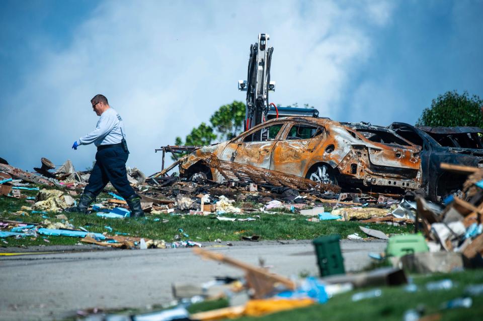 An investigator walks through the debris from a home explosion which occurred the day before on Rustic Ridge Drive in Plum, Pa., Sunday, Aug. 13, 2023.