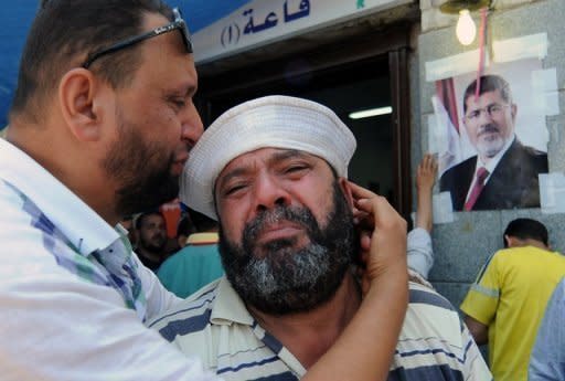 A man at the Muslim Brotherhood field hospital in Cairo on Saturday mourns the death of a relative in clashes overnight. Dozens of Mohamed Morsi's supporters were shot dead in the Egyptian capital on Saturday as violence erupted after a night of massive rallies for and against the ousted Islamist president