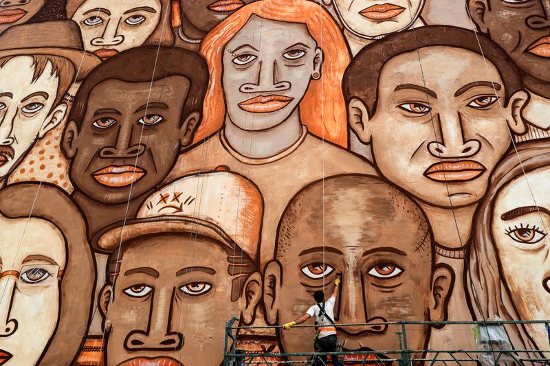 FILE PHOTO: Brazilian artist Mundano works on a mural with different colour paints made with dirt and mud brought from the site of the January 25, 2019 collapsed tailing dam owned by Brazilian mining company Vale SA to honour victims of the disaster, in Sa