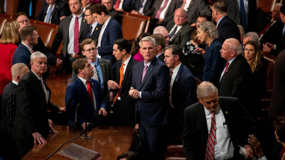 Representative Kevin McCarthy and other Congress members stand in the House chamber.