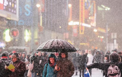 Gente paseando bajo la nevada que caía en Times Square, en Nueva York, el jueves 2 de enero (AFP | Don Emmert)