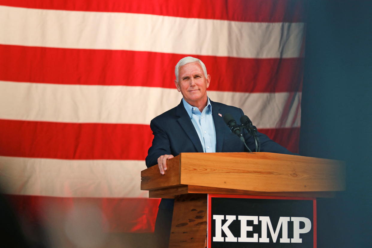 Former Vice President Mike Pence, behind a lectern that reads Kemp, speaks at a rally.