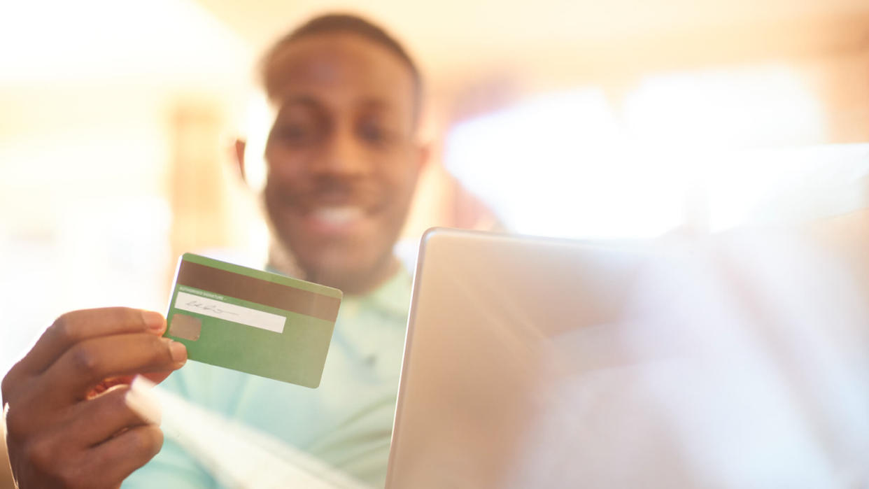 Young black male using digital tablet in the comfort of his home to do some online shopping.