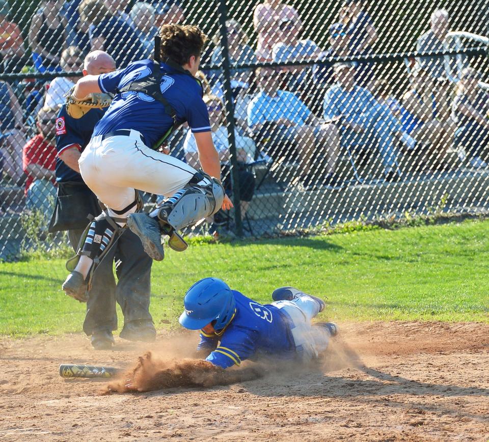 Clear Spring courtesy runner Lane Poffenberger slides under Catoctin catcher Dylan Nicholson, who leaps to catch an errant throw home, during the Blazers' eight-run fifth inning. Clear Spring defeated Catoctin 13-5 to win the Class 1A West Region II title.