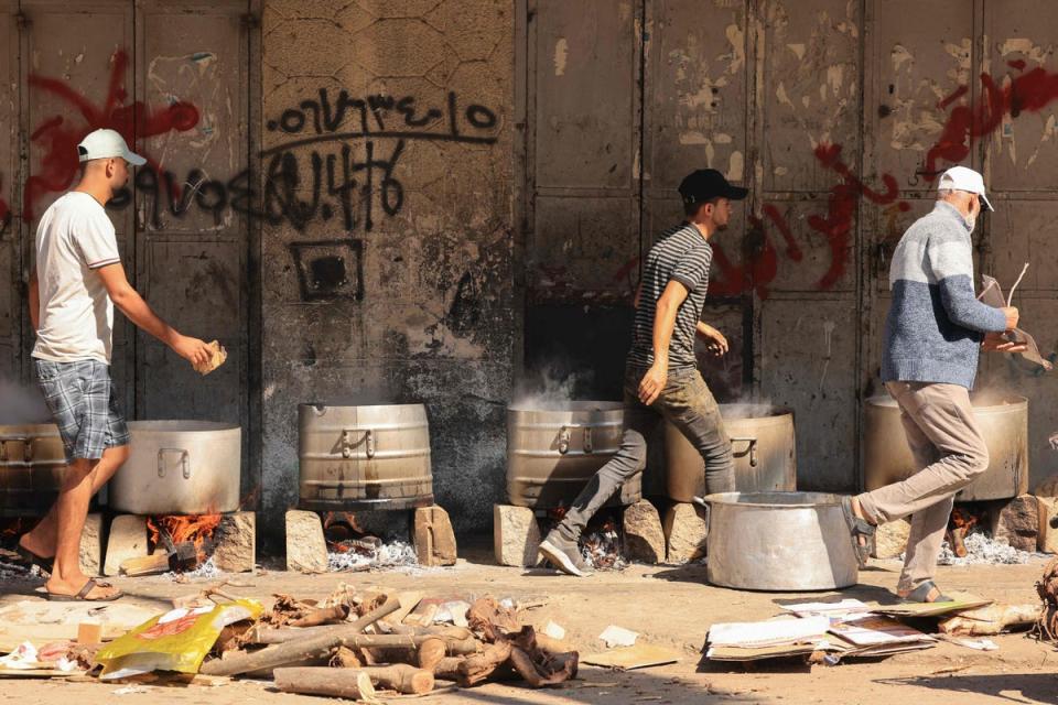 People cook on firewood amid shortages of fuel and gas in Gaza (AFP via Getty Images)