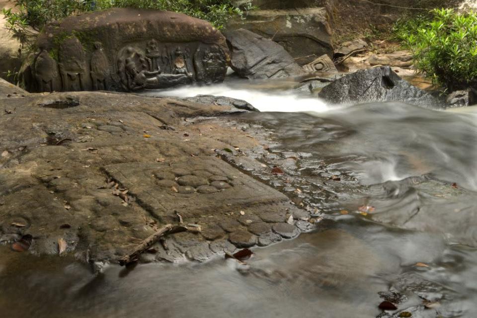 Kbal Spean consists of a series of stone carvings on the sandstone bed of the Stung Kbal Spean River about 25 km from the Angkor monuments.