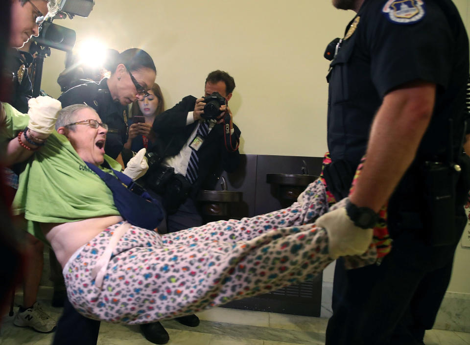 U.S. Capitol Police remove a woman from a protest in front of the office of Senate Majority Leader Mitch McConnell (R-Ky.) on Capitol Hill, June 22, 2017.