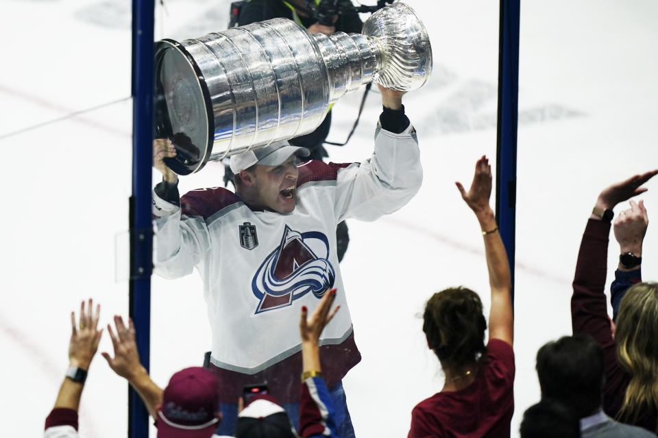 Colorado Avalanche defenseman Jack Johnson shows the Stanley Cup to the fans after the team defeated the Tampa Bay Lightning 2-1 in Game 6 of the NHL hockey Stanley Cup Finals on Sunday, June 26, 2022, in Tampa, Fla. (AP Photo/John Bazemore)