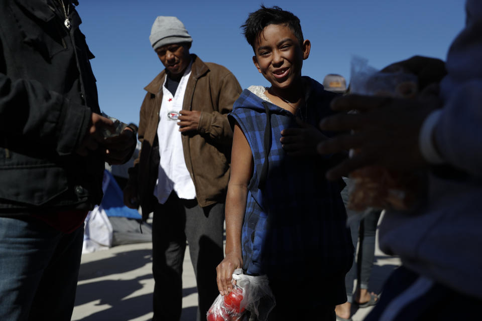 In this Dec. 3, 2018 photo, Honduran migrant Fernando Lopez, 12, who joined the caravan with his mother, sells apples for 6 pesos (30 cents) apiece inside the former concert venue Barretal, now serving as a shelter for more than 2,000 migrants, in Tijuana, Mexico. Facing the possibility of a months-long wait in Tijuana before even having an opportunity to request asylum in the United States, members of the migrant caravans that have arrived in Tijuana are looking for work. Some are creating their own informal businesses. (AP Photo/Rebecca Blackwell)