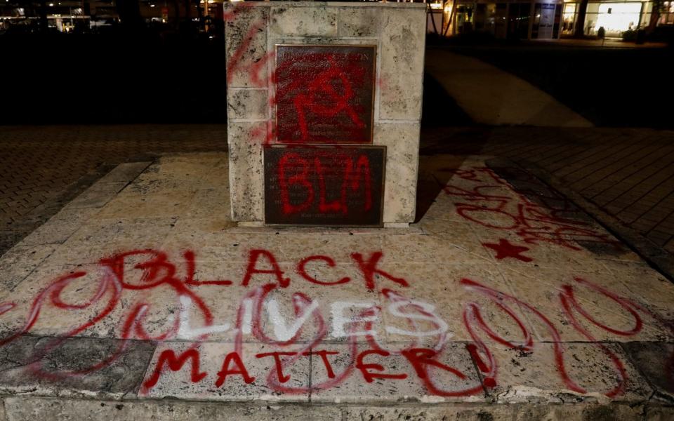 The Columbus statue in downtown Miami was covered with Black Lives Matter graffiti - MARCO BELLO/REUTERS