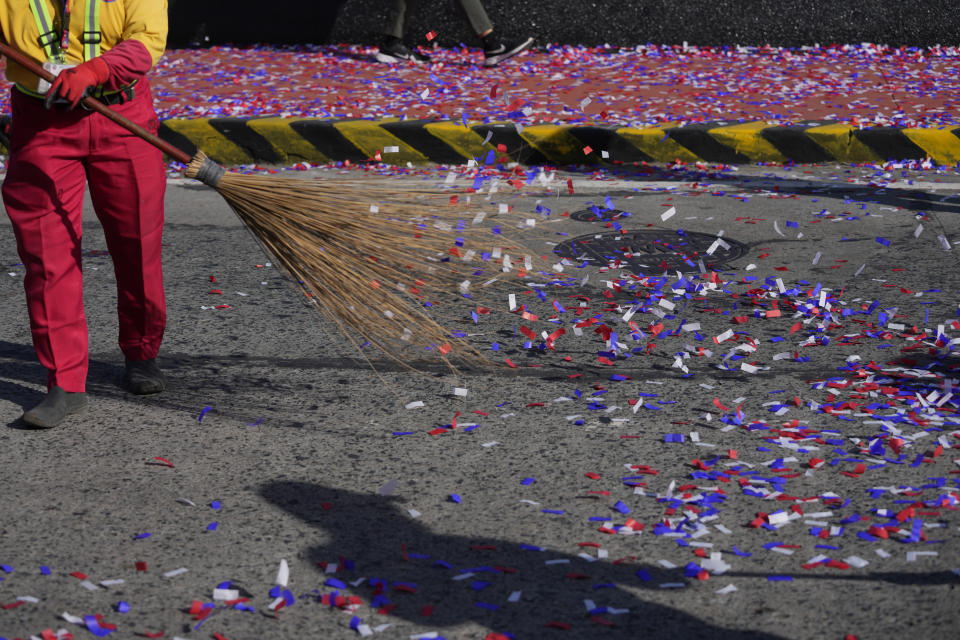 A worker sweeps confetti after ceremonies marking the 37th anniversary of the near-bloodless coup popularly known as "People Power" revolution that ousted the late Philippine dictator Ferdinand Marcos from 20-year-rule at the People's Power Monument in Quezon city, Philippines on Saturday Feb. 25, 2023. It is the first year marking the event under the rule of Marcos Jr. (AP Photo/Aaron Favila)