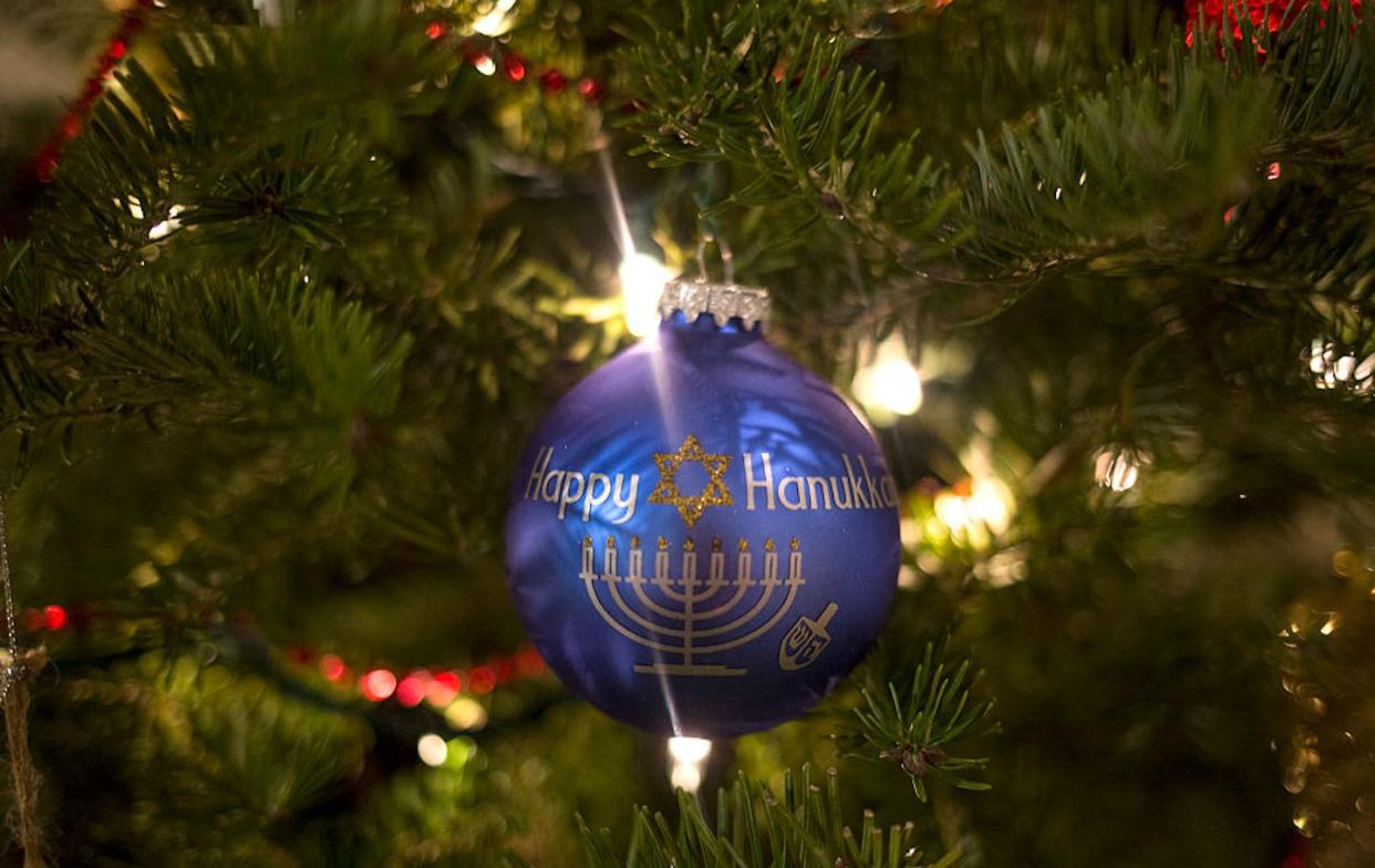 Lots of families wrestle with how – and whether – to celebrate both Hanukkah and Christmas. <a href="https://www.gettyimages.com/detail/news-photo/happy-hanukkah-ornament-hangs-on-the-christmas-tree-at-amy-news-photo/630848980?adppopup=true" rel="nofollow noopener" target="_blank" data-ylk="slk:Brianna Soukup/Portland Portland Press Herald via Getty Images;elm:context_link;itc:0;sec:content-canvas" class="link ">Brianna Soukup/Portland Portland Press Herald via Getty Images</a>