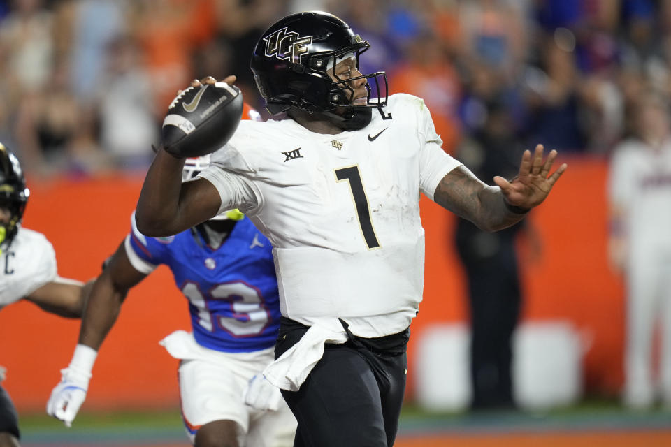 Central Florida quarterback KJ Jefferson (1) throws a pass as he is pressured by Florida defensive back Aaron Gates (13) during the first half of an NCAA college football game, Saturday, Oct. 5, 2024, in Gainesville, Fla. (AP Photo/John Raoux)