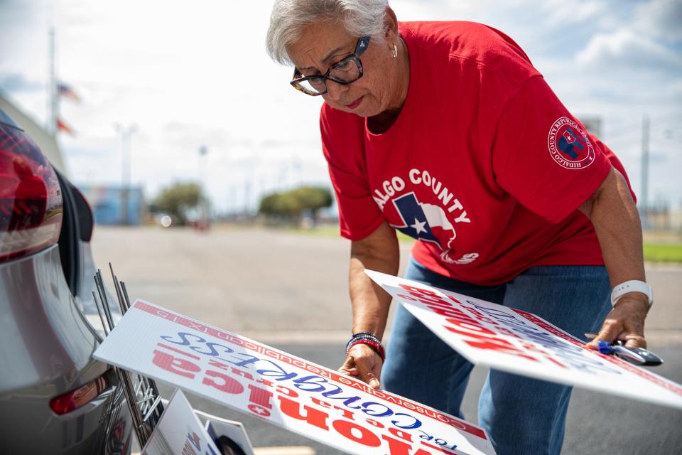 Hilda Garza DeShazo, 68, secretary for Hidalgo County Republican Party, unloads campaign yard signs from her vehicle parked outside of GOP headquarters on Oct. 6 in McAllen, Texas.