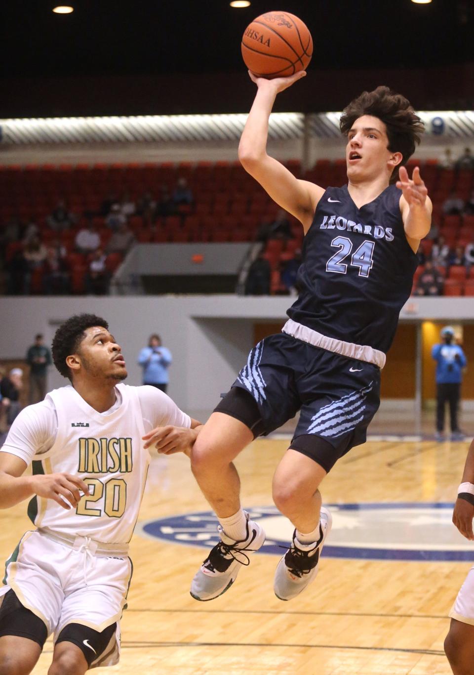 Hayden Nigro, 24, of Louisville goes to the basket while being guarded by Ramar Pryor, 20, of Akron St. Vincent-St. Mary during their DII regional final at the Canton Memorial Civic Center on Saturday, March 12, 2022.