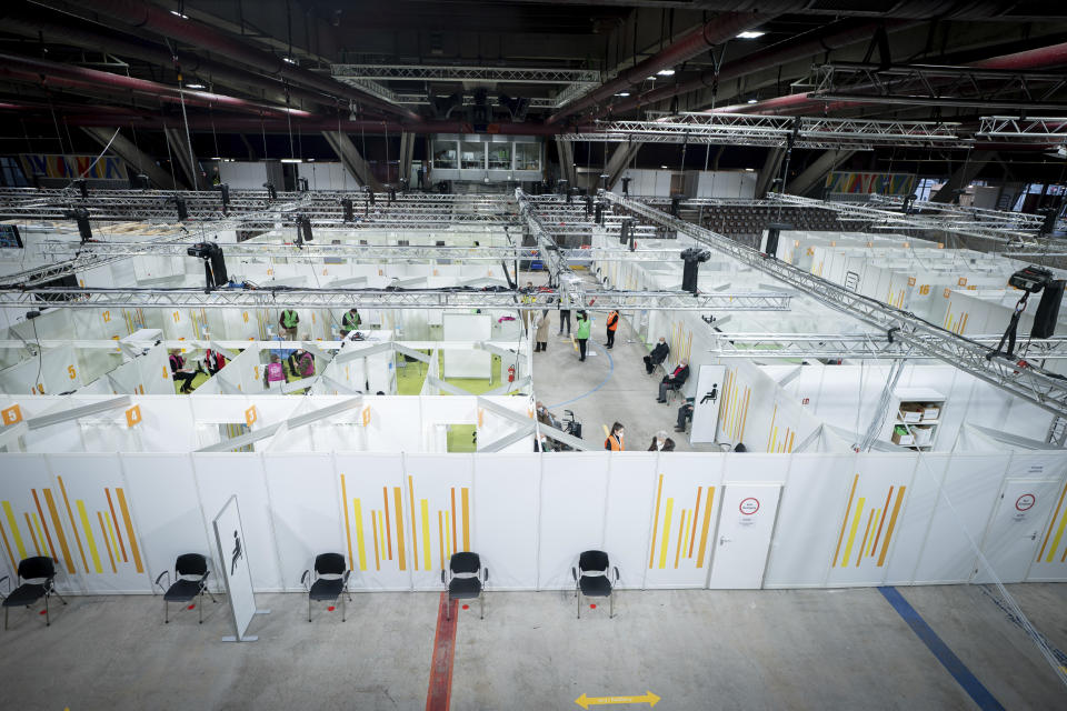 People stay in the new open Erika-Hess-Eisstadion vaccine center in Berlin, Germany, Thursday, Jan. 14, 2021. (Kay Nietfeld/Pool via AP)