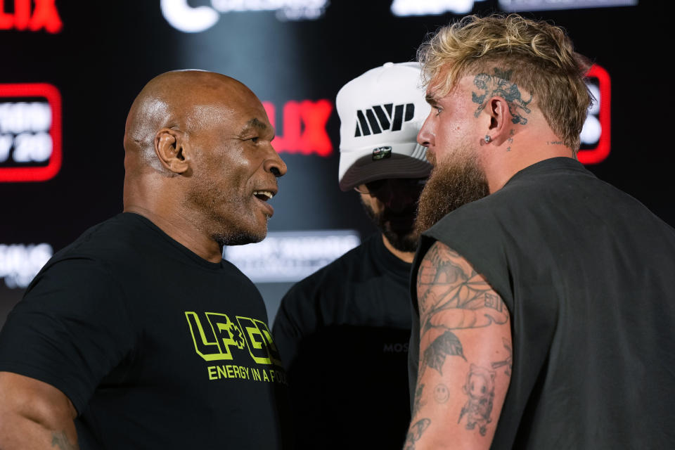 Mike Tyson, left, and Jake Paul, right, face off during a news conference promoting their upcoming boxing bout, Thursday, May 16, 2024, in Arlington, Texas. The fight is scheduled for July 20. (AP Photo/Sam Hodde)