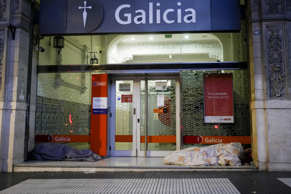 Personas sin hogar duermen en la entrada de una entidad bancaria en Buenos Aires, Argentina, el miércoles 27 de septiembre de 2023. (AP Foto/Natacha Pisarenko)