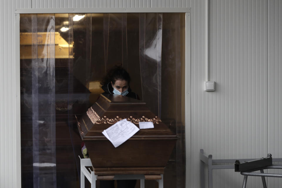 A worker moves a casket into an overflow cold storage container placed outside a crematorium in Ostrava, Czech Republic, Thursday, Jan. 7, 2021. The biggest crematorium in the Czech Republic has been overwhelmed by mounting numbers of pandemic victims. With new confirmed COVID-19 infections around record highs, the situation looks set to worsen. Authorities in the northeastern city of Ostrava have been speeding up plans to build a fourth furnace but, in the meantime, have sought help from the government’s central crisis committee for pandemic coordination. (AP Photo/Petr David Josek)