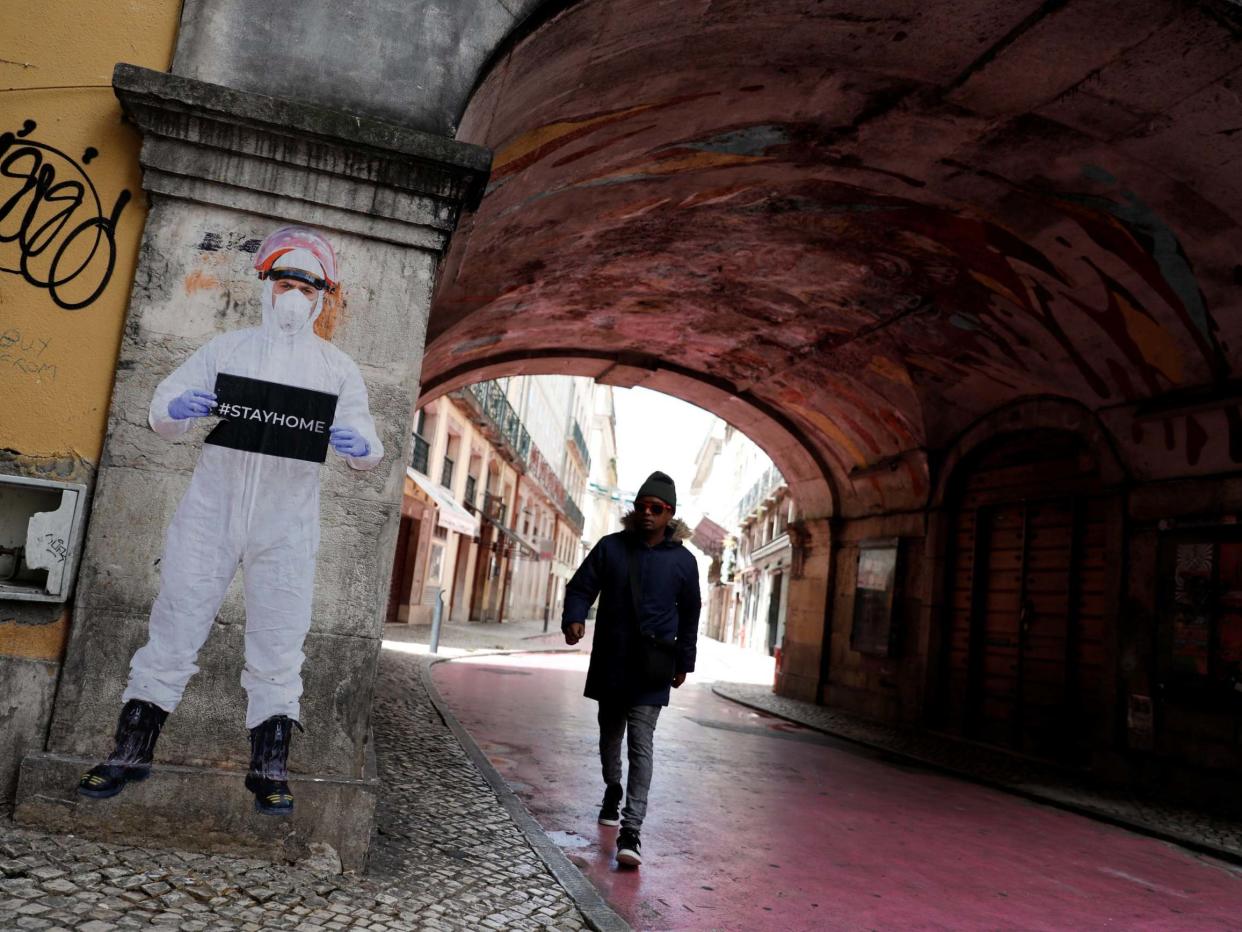 A man walks next to a picture of photographer Salvador Colaco in downtown Lisbon: Reuters