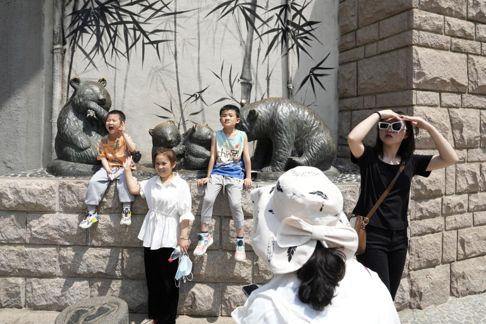 Visitors pose for photos near the Panda enclosure in the zoo on the last day of the May Day holidays in Beijing, Wednesday, May 3, 2023. (AP Photo/Ng Han Guan)